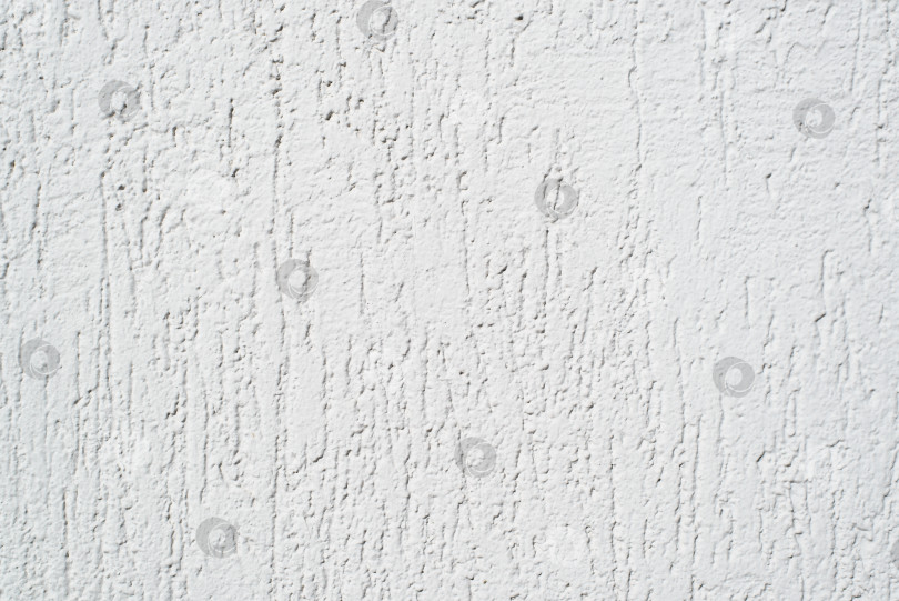 Скачать Белая стена, обработанная декоративной штукатуркой для наружного использования, крупным планом. Текстурированный фон с царапинами фотосток Ozero
