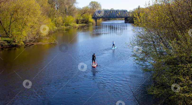 Скачать Двое мужчин плавают на доске для гребли по реке Спринг.Я не могу видеть его лица. фотосток Ozero