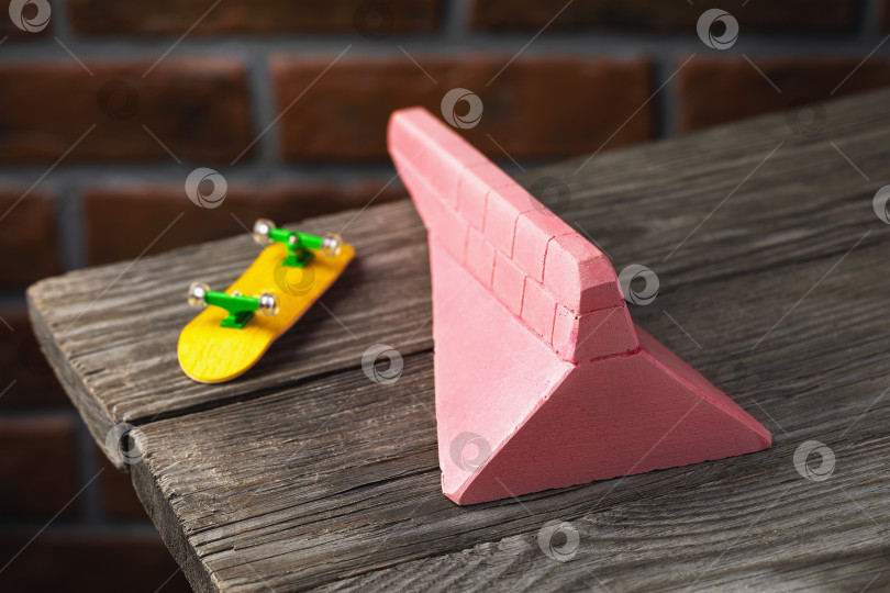 Скачать Гипсовый пандус розового цвета и желтый гриф на деревянном столе фотосток Ozero