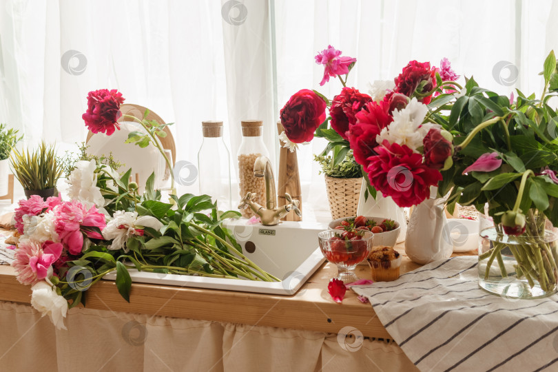 Скачать Кухонная столешница украшена пионами. Интерьер украшен весенними цветами. фотосток Ozero