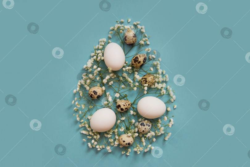 Скачать Форма пасхального яйца, выполненная из различных пасхальных декоративных элементов. Разные яйца на синем фоне, украшенные натуральными растительными элементами. Плоское расположение, вид сверху, пустое место для текста. фотосток Ozero