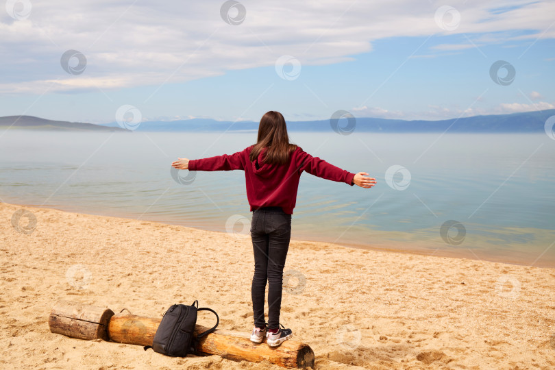 Скачать Молодая девушка-путешественница наслаждается прекрасным видом на озеро Байкал летом. Песчаный пляж острова Ольхон. фотосток Ozero
