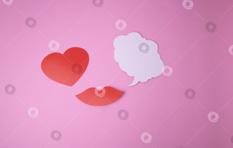 Скачать На розовом фоне бумажные красные губы, сердечко и белое облако вместо слов. фотосток Ozero