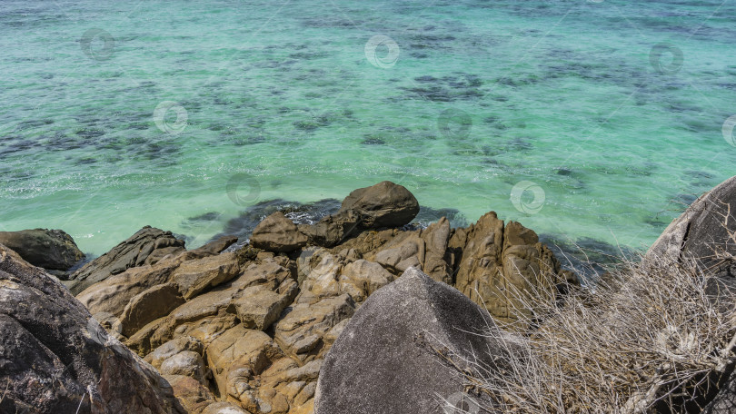 Скачать Скалистый склон острова в бирюзовом океане. фотосток Ozero
