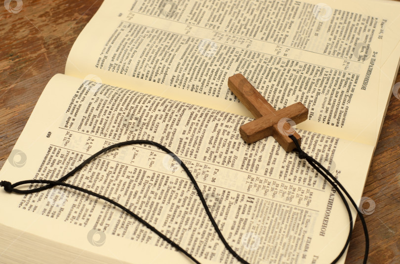 Скачать Деревянный христианский крест с веревкой на открытой святой Библии. фотосток Ozero