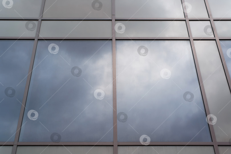 Скачать Фасад стеклянного здания снаружи, крупный план. Отражение облачного неба в очках. фотосток Ozero