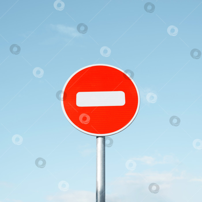 Скачать Круглый дорожный знак "Въезд запрещен" на столбе на фоне ясного голубого неба. фотосток Ozero