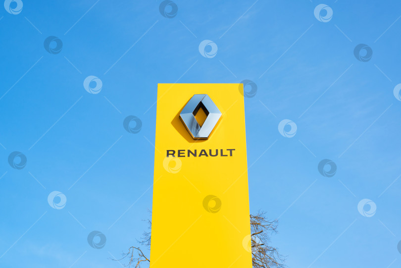 Скачать Желтая вывеска французской автомобильной корпорации Renault снаружи, на фоне ясного голубого неба в солнечный день. Смоленск, Россия 18.04.2021 фотосток Ozero