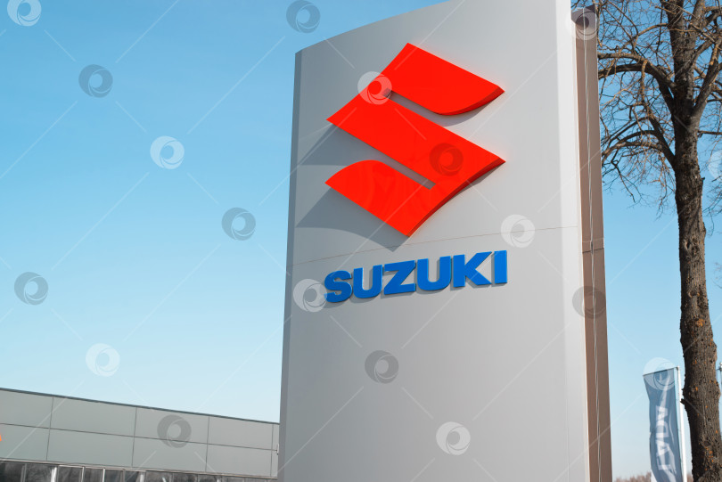 Скачать Вывеска японской инжиниринговой компании Suzuki крупным планом, днем на улице. Смоленск, Россия 18.04.2021 фотосток Ozero