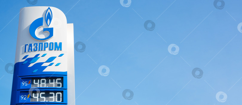 Скачать Логотип российской транснациональной энергетической компании "Газпром", информационное табло с ценами на бензин снаружи, фон ясного голубого неба. Баннер, скопируйте место для вашего текста. Смоленск, Россия 18.04.2021 фотосток Ozero