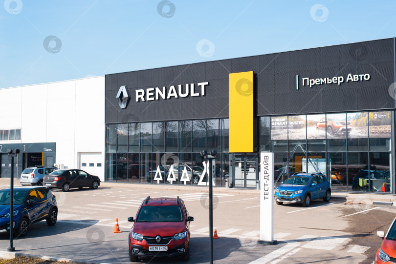 Скачать Автосалон французской автомобильной корпорации Renault, снаружи. Фасад здания, парковка и вывеска с логотипом на фоне ясного голубого неба. Смоленск, Россия 18.04.2021 фотосток Ozero