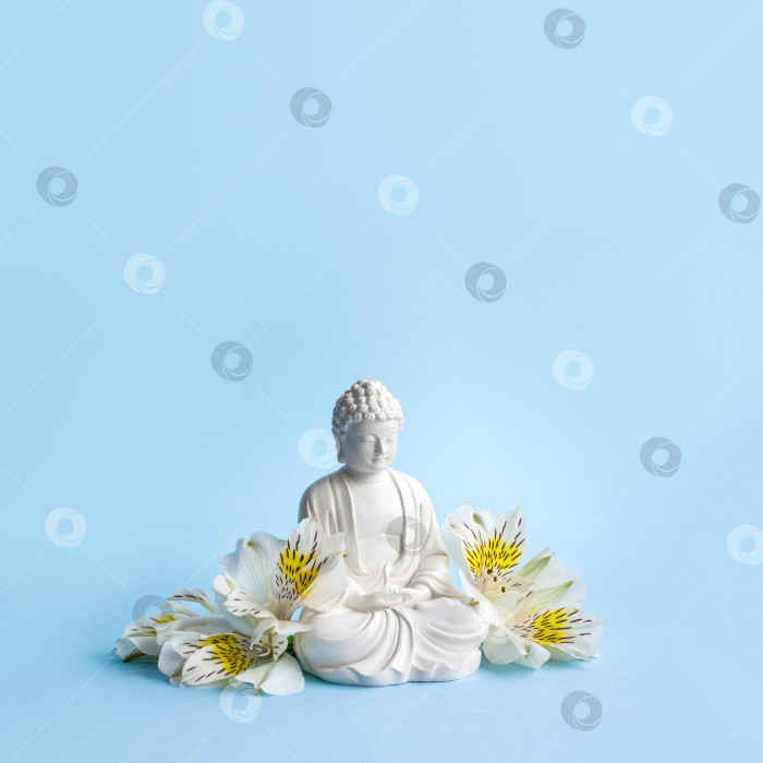 Скачать Фигурка Будды и белые цветы. Буддизм. Ментальное здоровье и медитация. фотосток Ozero