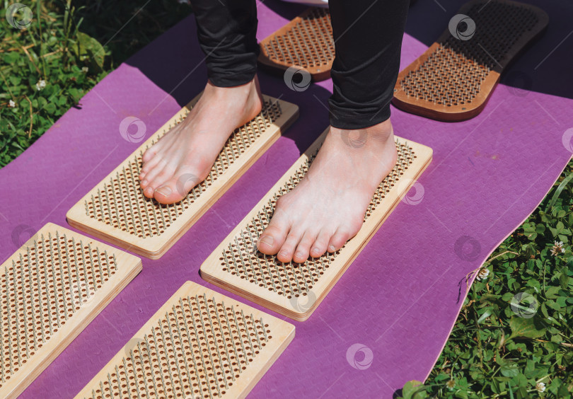 Скачать Женщина стоит на доске садху. Ноги крупным планом .ногти для йоги на природе. фотосток Ozero