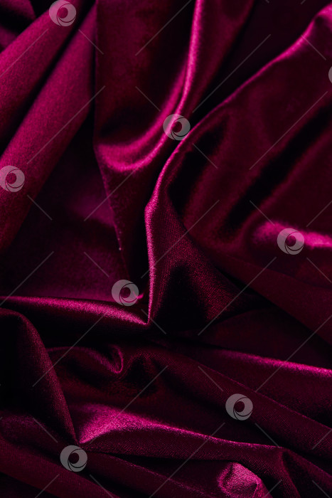 Скачать Текстура фона из пурпурной складчатой бархатной ткани. Пустой темно-красный тканевый фон из мягкого и гладкого текстильного материала. фотосток Ozero