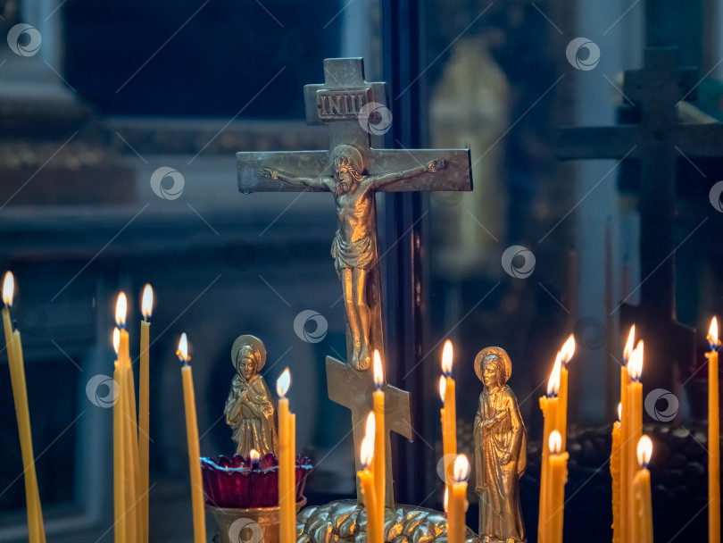 Скачать Церковные свечи горят перед статуэткой распятия. фотосток Ozero