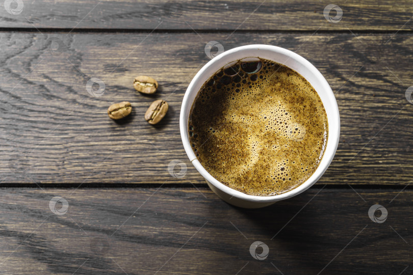Скачать Одноразовый стаканчик с черным кофе на столике наверху фотосток Ozero