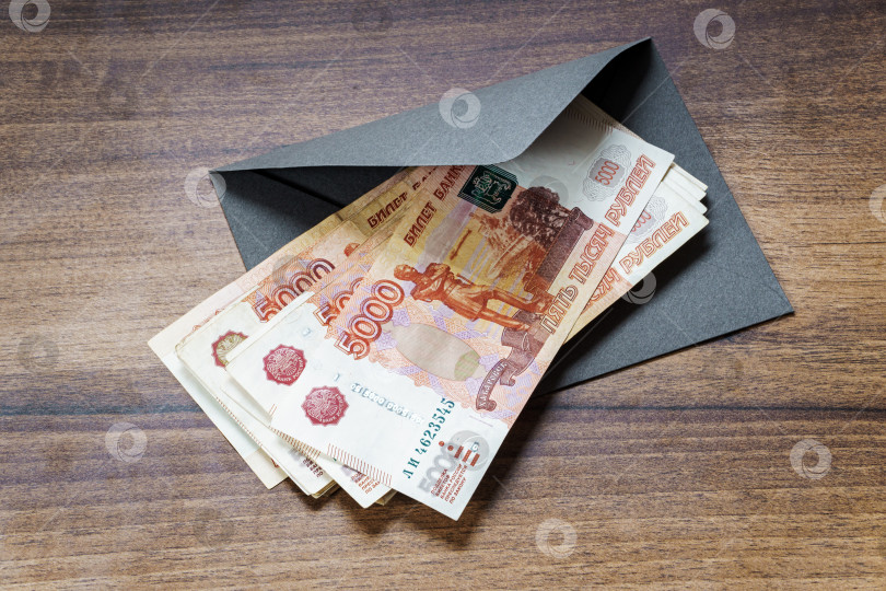 Скачать Банкноты в российских рублях и конверт на столе фотосток Ozero