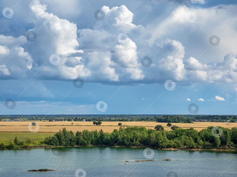 Скачать Удивительный пейзаж с большими белыми кучевыми облаками над озером фотосток Ozero