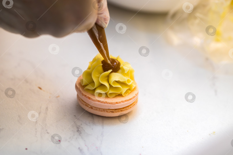 Скачать шеф-кондитер выдавливает начинку на печенье macarons. крупный план. концепция домашней пекарни. фотосток Ozero