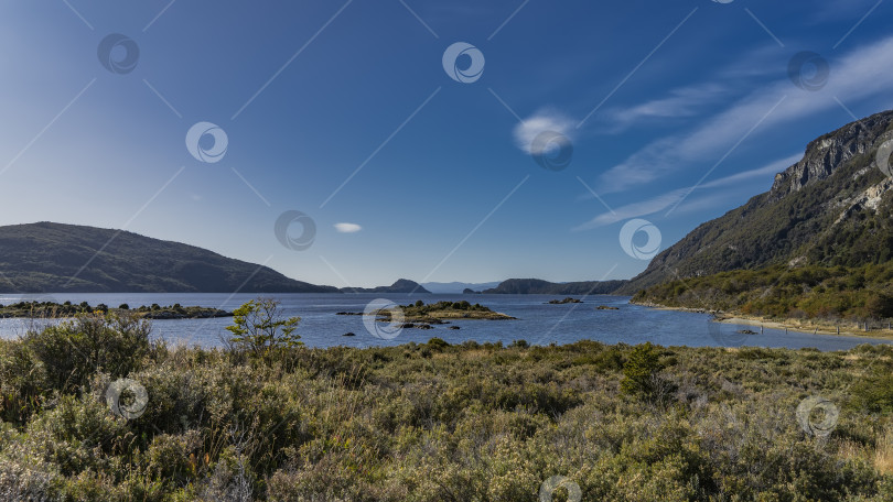 Скачать Спокойное голубое озеро окружено горами. фотосток Ozero