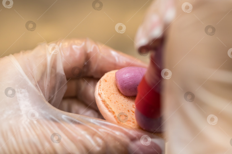 Скачать шеф-кондитер выдавливает начинку на печенье macarons. крупный план. концепция домашней пекарни. фотосток Ozero