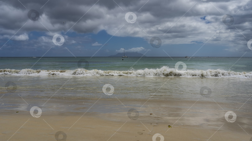 Скачать Волны бирюзового океана накатывают на берег с пеной и брызгами. фотосток Ozero