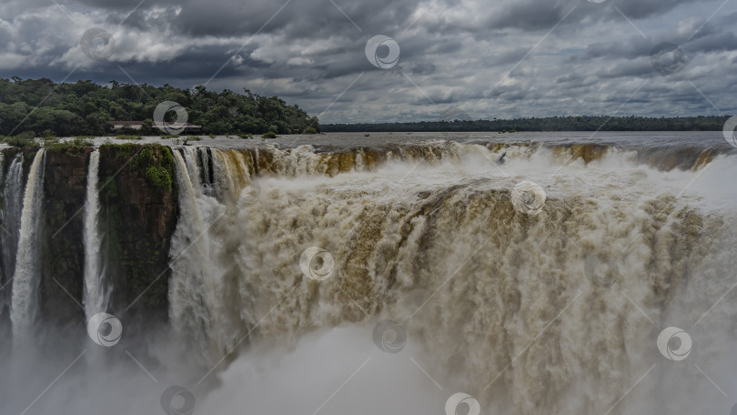 Скачать Мощные потоки воды бурлят и пенятся, обрушиваясь в ущелье. фотосток Ozero