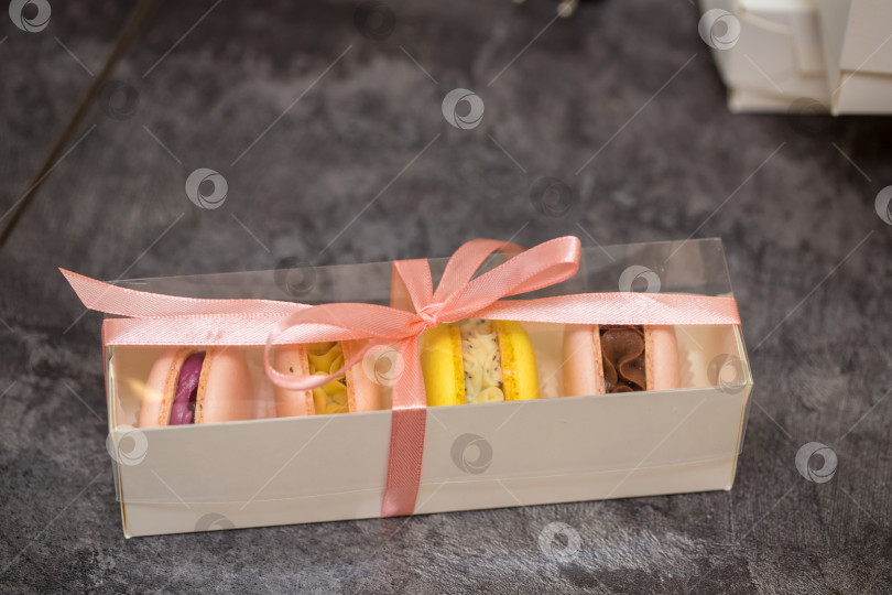 Скачать на столе коробка с миндальным печеньем, перевязанная розовой лентой. концепция домашней пекарни. фотосток Ozero