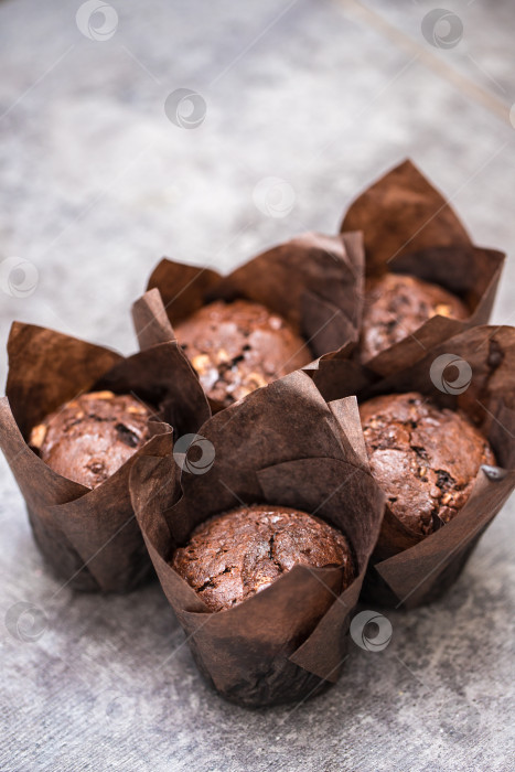 Скачать шоколадные кексы в бумажной обертке на столе. концепция домашней пекарни. фотосток Ozero