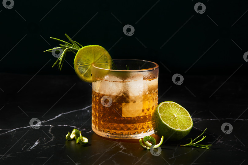 Скачать Алкогольный или безалкогольный коктейль с лаймом и розмарином на столе из темного мрамора фотосток Ozero