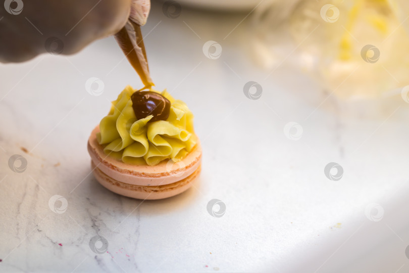 Скачать шеф-кондитер выдавливает начинку на печенье macarons. крупный план. концепция домашней пекарни. фотосток Ozero