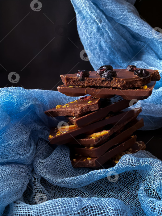 Скачать Кусочки шоколада с орехами и изюмом на темном фоне фотосток Ozero