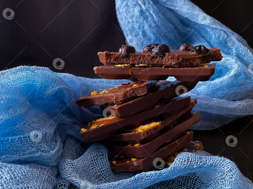Скачать Кусочки шоколада с орехами и изюмом на темном фоне фотосток Ozero