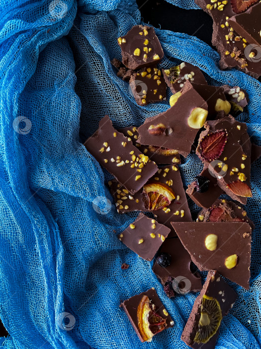 Скачать Кусочки домашнего шоколада с фундуком и орешками на черном фотосток Ozero