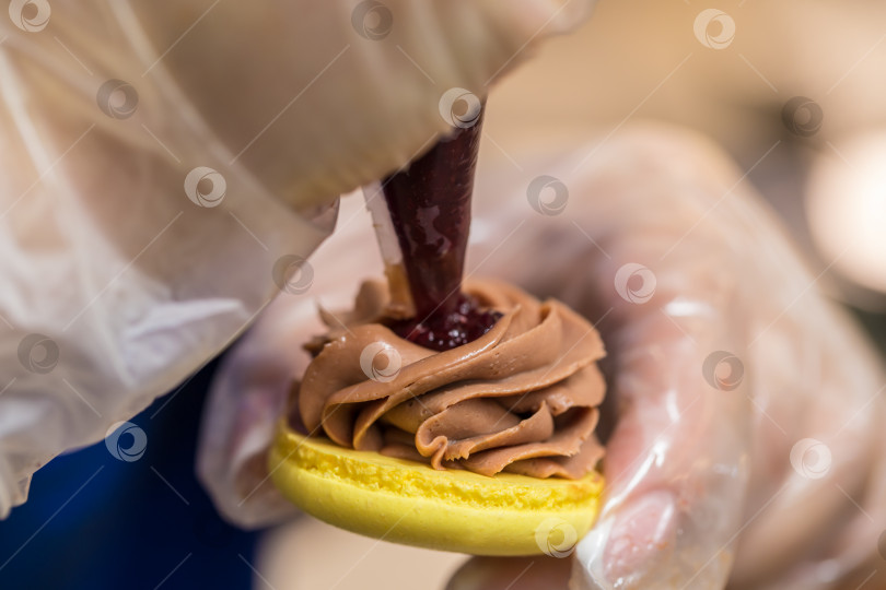 Скачать шеф-кондитер выдавливает начинку на печенье macarons. крупный план. концепция домашней пекарни. фотосток Ozero