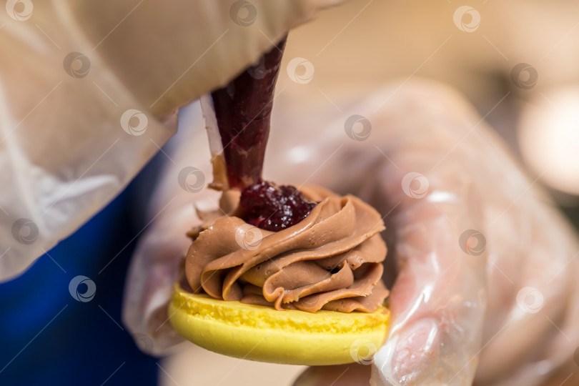 Скачать шеф-кондитер выдавливает начинку на печенье macarons. крупный план. концепция домашней пекарни. фотосток Ozero