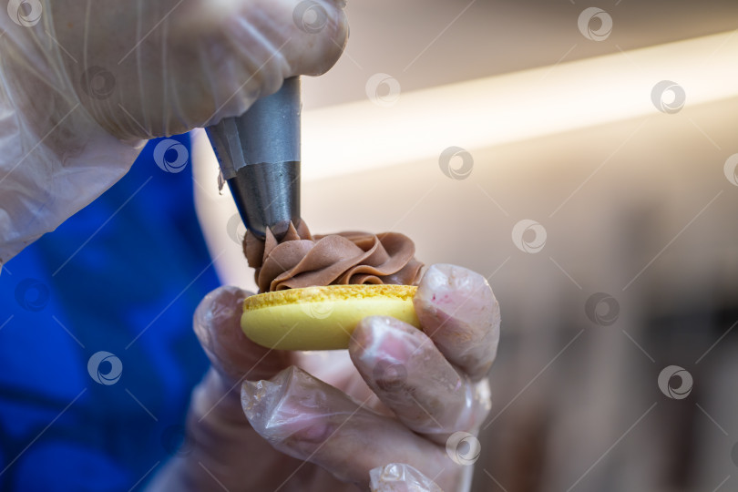 Скачать шеф-кондитер выдавливает начинку на печенье macarons. крупный план. концепция домашней пекарни. фотосток Ozero