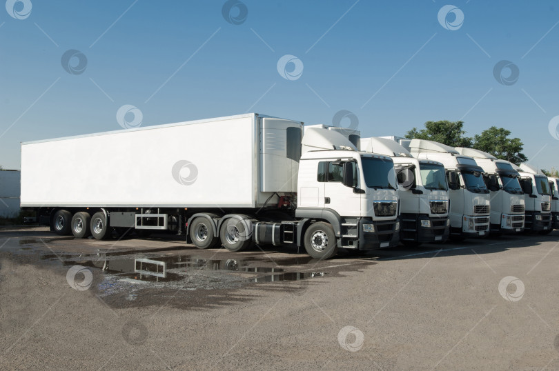 Скачать грузовики стоят на стоянке в ряд фотосток Ozero