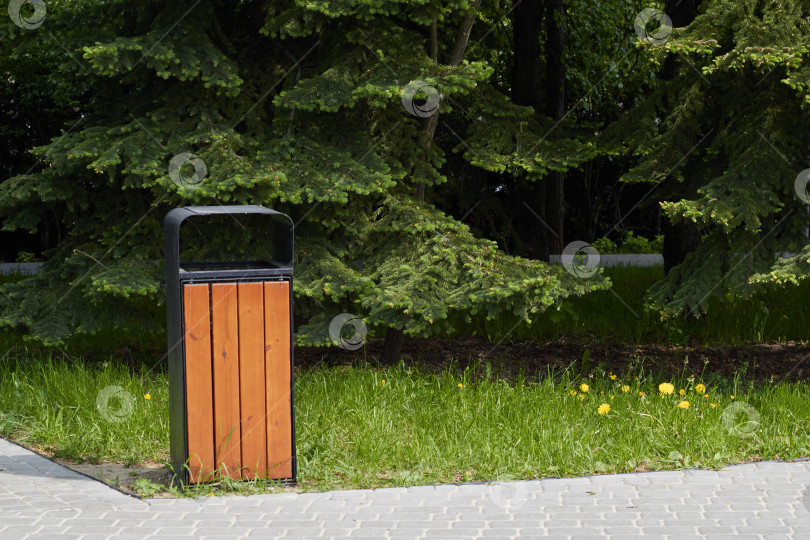 Скачать Фотография деревянного мусорного бака на дорожке в парке. фотосток Ozero