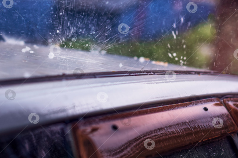 Скачать Сильный дождь с градом бьет по крыше автомобиля.  Дефлектор двери автомобиля крупным планом. фотосток Ozero
