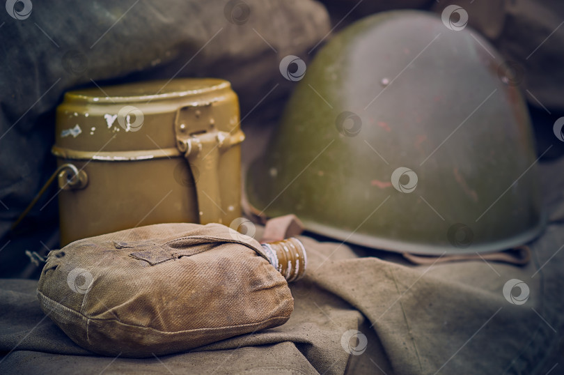 Скачать Военная фляжка в футляре с военным шлемом и аптечкой в размытом виде. фотосток Ozero