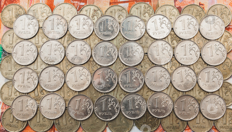 Скачать многие монеты достоинством в 1 рубль лежат на российских деньгах. фотосток Ozero