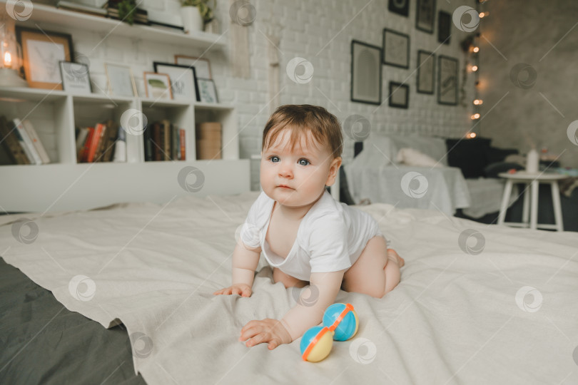 Скачать Портрет 6-месячного ребенка, ползающего по кровати. малыш улыбается и смотрит в камеру. фотосток Ozero