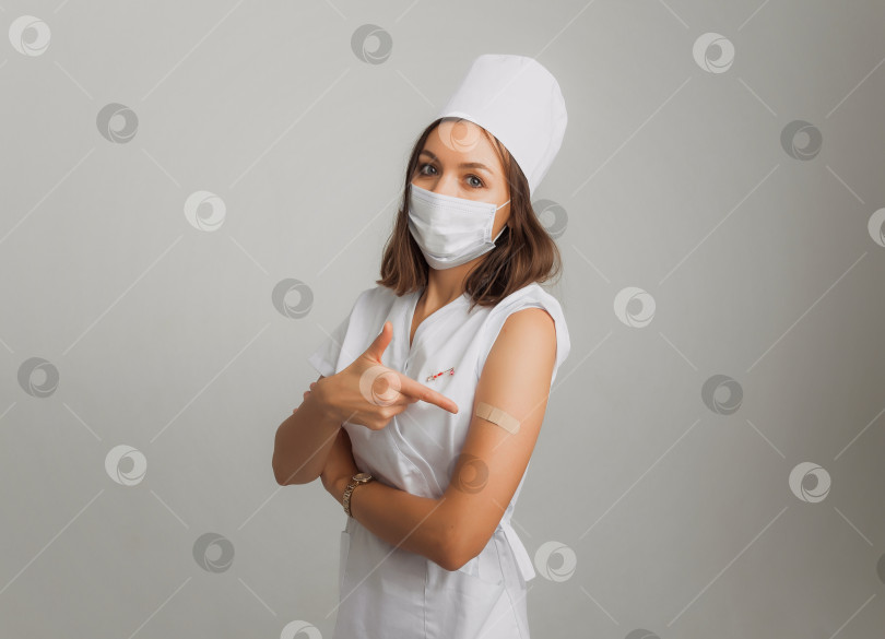 Скачать женщина-врач или медсестра показывает свою руку с пластырем после вакцинации. концепция вакцинации. фотосток Ozero