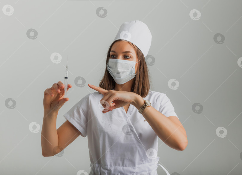 Скачать женщина-врач в медицинской маске держит в руках шприц. концепция вакцинации. фотосток Ozero