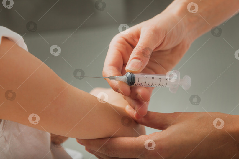 Скачать врач делает мальчику прививку в руку. Вспышка коронавируса. Концепция вакцинации. фотография высокого качества фотосток Ozero