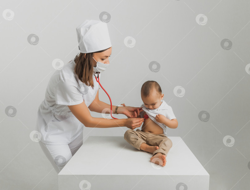 Скачать Детский врач осматривает годовалого мальчика с помощью стетоскопа в больничном центре. концепция здравоохранения фотосток Ozero