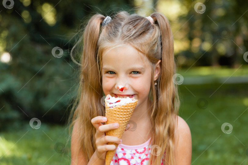 Скачать Красивая маленькая блондинка ест мороженое летом в парке. веселая девушка с мороженым. фотосток Ozero