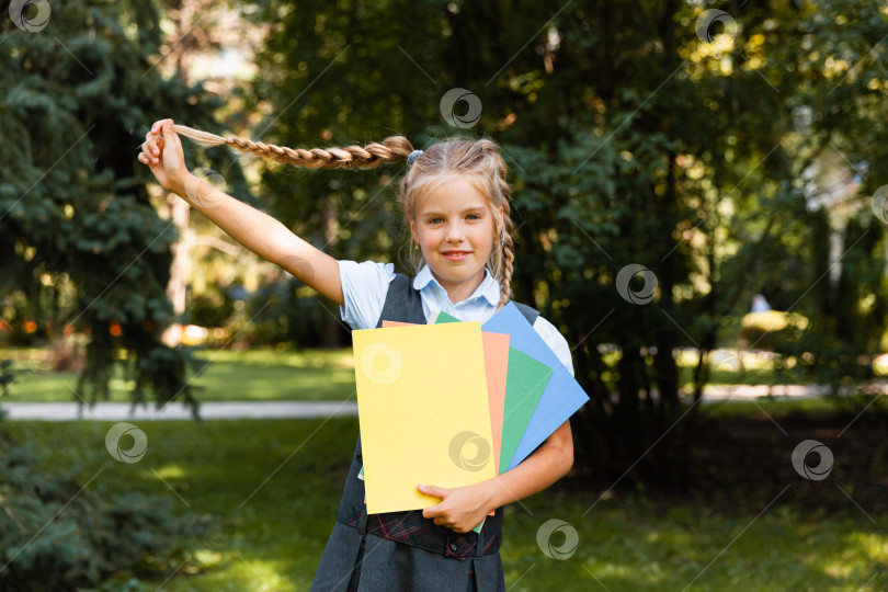 Скачать Школьница идет в школу с поднятыми руками на фоне парка. девочка в школьной форме в парке. фотосток Ozero