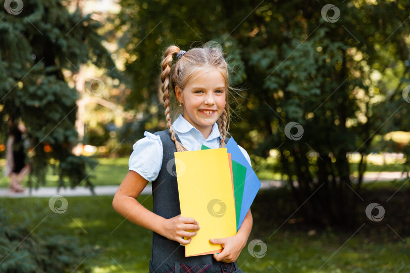 Скачать Школьница идет в школу с поднятыми руками на фоне парка. девочка в школьной форме в парке. фотосток Ozero